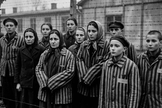 Schwarz-Weiß-Bild von Holocaust-Opfern mit digital geglätteten Gesichtern und unlogischen Schatten, Kennzeichen von KI Fake Holocaust Bildern.