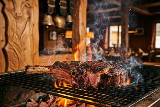 Ein perfekt gegrilltes Tomahawk-Steak mit zartrosa Kern und duftendem Rauch über Buchenholzflammen – das Steakhouse Appenzell Waldegg lädt ein.
