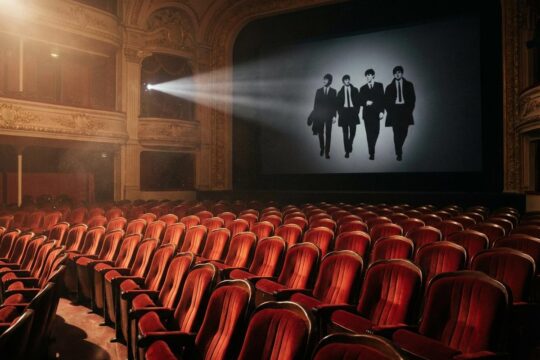 Leerer Kinosaal: Rote Plüschsessel warten auf die Projektion der Beatles-Silhouetten. Ein Strahl kündigt die neuen Beatles Filme an.