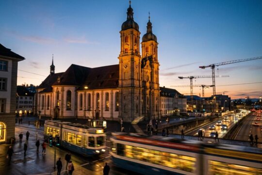 Dunkle Dämmerung in St.Gallen: Eine Strassenbahn saust vorbei, während die Türme der Stiftskirche im Licht erstrahlen, ein Spiegelbild der aktuellen News St.Gallen.