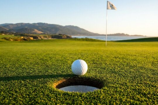 Ein weißer Golfball liegt perfekt auf dem Fairway, kurz vorm Loch. Die Fahne weht, ein Zeichen für Farmers Insurance Open Ergebnisse.