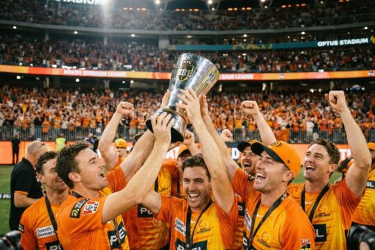 Die Perth Scorchers Big Bash League Sieger jubeln ausgelassen und stemmen die glänzende Trophäe über ihren Köpfen vor einer feiernden Stadionkulisse.