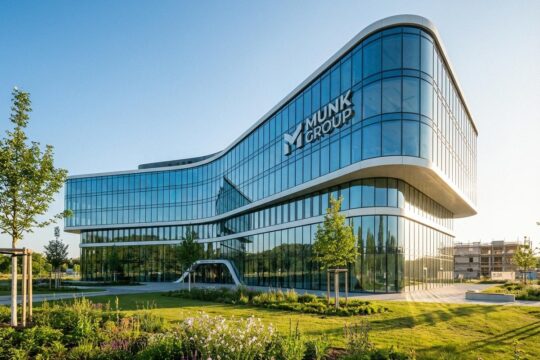 Modernes, futuristisches Munk Group Gebäude mit Glasfronten und Grünflächen, das zukunftsweisende Munk Group Investitionen in Deutschland abbildet.