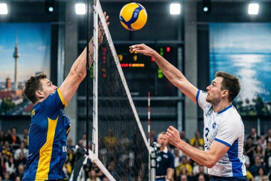 Intensiver Volleyball-Block am Netz im Duell BR Volleys vs VfB Friedrichshafen. Zwei Spieler kämpfen um den schwebenden Ball.