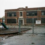 Primarschule Reute geschlossen: Ein verriegeltes Metalltor, menschenleere Schaukeln und ein stilles Schulgebäude zeigen die Sperrung.