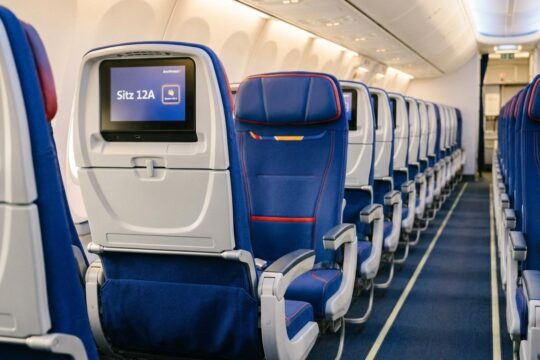 Nahaufnahme eines leeren Fensterplatzes im Southwest Airlines Flugzeug. Das Display "Sitz 12A Zugewiesen" visualisiert die neuen Southwest Airlines feste Sitzplätze.