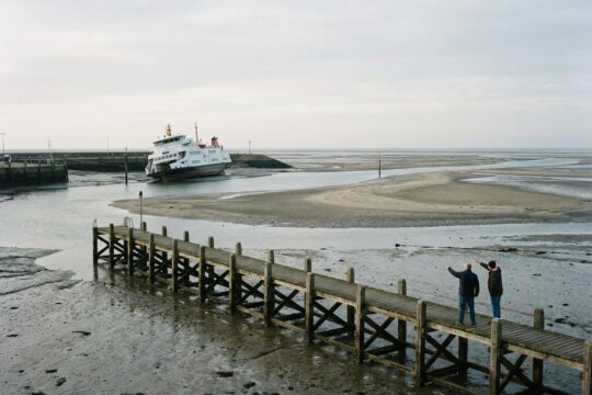 Karger Meeresboden, leerer Steg. Fähre liegt im Flachwasser fest. Frustrierte Personen wegen Fähre Hiddensee Ausfall.