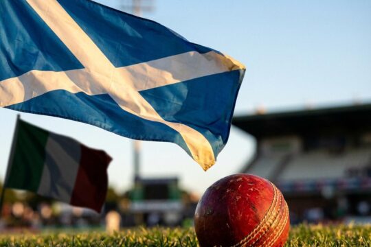 Leuchtende schottische Flagge, Cricketkugel, schemenhafte italienische Flagge. Siegesszene der Cricket WM Schottland Italien.