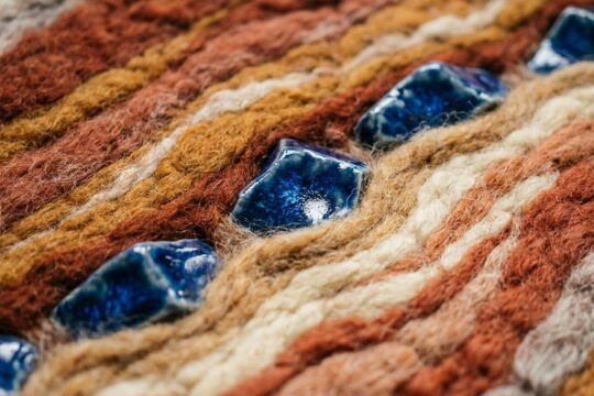 Der Porzellanteppich Leuchtenburg in Nahaufnahme zeigt erdige Wollschichten wie Buntsandstein und blaues Porzellan in kristallinen Formen.