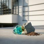 Glänzende Glasschlacke, Zementklinker und Linsen liegen ästhetisch auf Beton, dahinter verschwommen das Bauhaus Dessau. Fokus der Ausstellung Bauhaus Dessau.