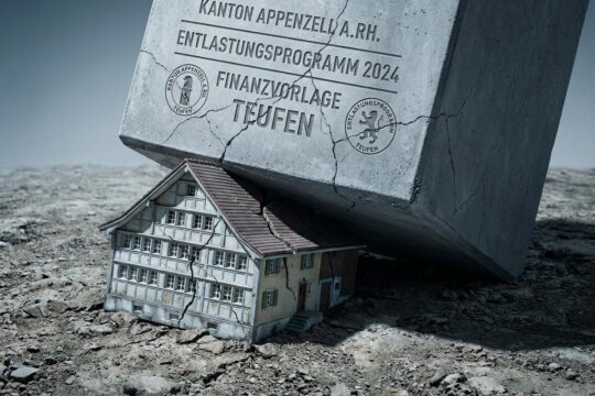 Ein Miniatur-Bauernhaus (Teufen) steht unter einem Betonblock, der kantonale Vorlagen symbolisiert. Es verdeutlicht Teufens Kritik an kantonalen Vorlagen und der Lastenverschiebung.