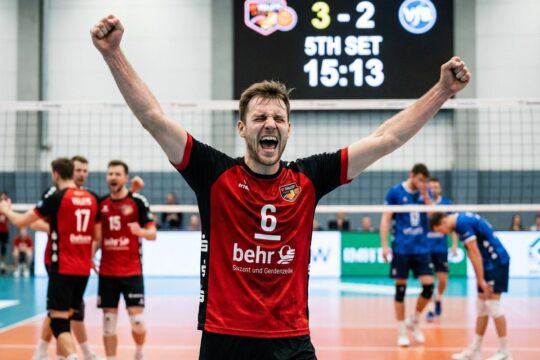 Ein athletischer BR Volleys Spieler jubelt mit strahlendem Gesicht und erhobenen Armen über den entscheidenden BR Volleys Sieg gegen Friedrichshafen.