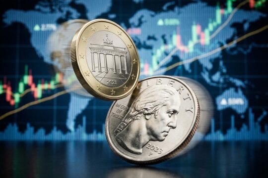 Glänzende Euro- und US-Viertel-Dollar-Münzen im dynamischen Kräftemessen, symbolisch für die Euro Dollar Kurs Entwicklung vor unscharfem Finanzchart.